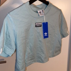 ADIDAS Cropped Tee ”mintgreen” - Mintgrön croppae t-shirt från Adidas! Storlek S (36) men mer som en XS i storleken😄 Oanvänd! Färgen är som på andra bilden. Superfin men tyvärr för liten för mig. Köpt för 300kr!