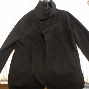 Svart kort kappa - Storlek S/36 - Denna fina kappa är kort och tunn. Den är köpt från en butik i Frankrike cirka 2 år sedan. Använd max 1 gång och är helt i nyskick utan några skador! Kappan är i  storlek - 36/S