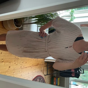 Klänning med paljettdetaljer - Fin ljusrosa klänning med paljettdetaljer fram. Passar bra till sommarens festligheter. Använd fåtal gånger.