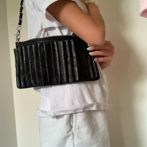 Svart och fin väska - Den har fyra fack och är en Axel väska man kan använda den typ närsomhelst