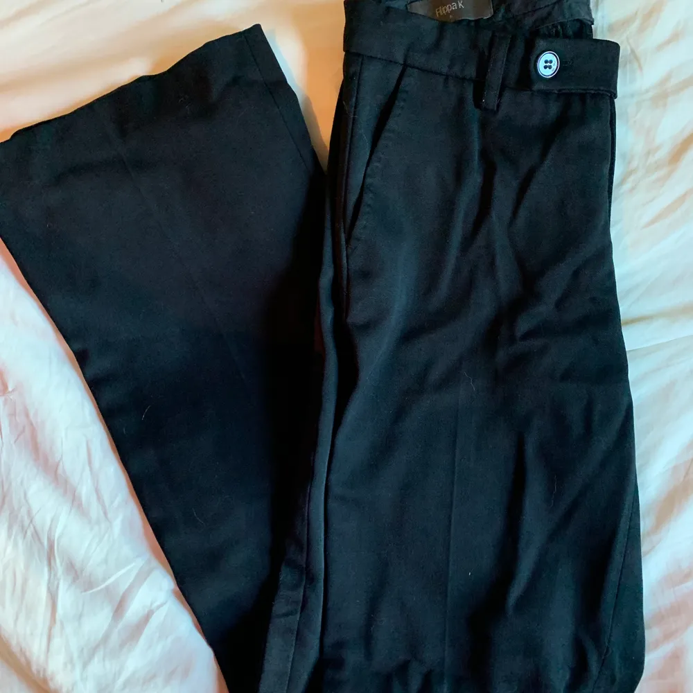 Svarta kostymbyxor med utvsvängda ben i highwaist modell storlek S. Märke Filippa K, trendiga vida byxor med svart sidorevär.. Jeans & Byxor.