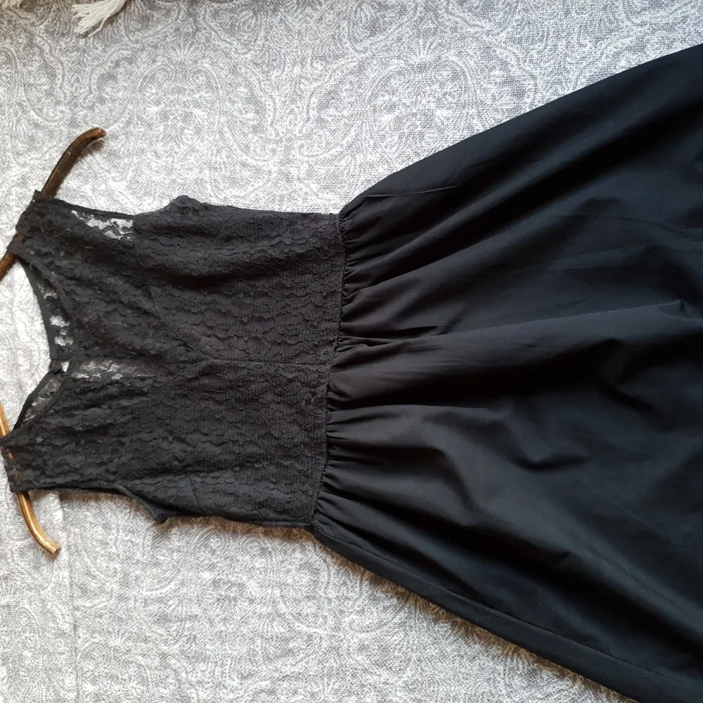 En tunn svart klänning med spets.. Klänningar.