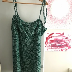 somrig grönblommig klänning - en somrig grön klänning med vita blommor på från förra året! sparsamt använd! strl L men passar mig med M. kom privat för mer info/bilder<3