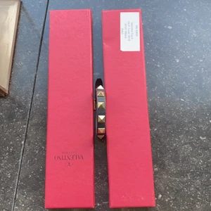 Valentino armband - Säljer detta fina Valentino armband som är svarta med guld/silvriga nitar på💕 skriv vid intresse