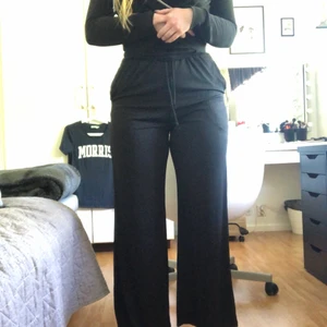 Svarta ribbade byxor - Svarta ribbade byxor från SHEIN, säljs pga att de är lite tajta i midjan på mig, använda en kväll. Bra längd på mig som är ca. 170cm lång.