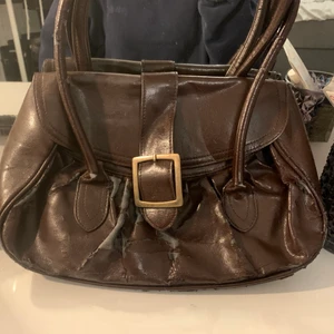 Brun handväska  - I ganska dåligt skick och därav det billiga priset. Men den går fortfarande att använda och är väldigt snygg. Köparen står för frakten 🥰