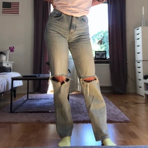 90's high waist jeans - Gina Tricot ikoniska 90s high waist jeans i färgen lt blue destroy i storleken 34. Jag älskar dessa jeans men dem har blivit för små för mig! Inga fläckar, inte trasiga, i fint skick! Använd en del. Nypris 599 kr