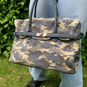 Kamouflagemönstrad handväska som är köpt på second hand, rymmer mycket med tre fickor, skicka dm för mer bilder. Hör av dig för frakt