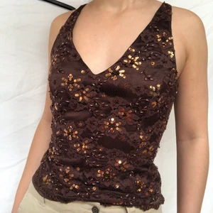Brunt paljett linne - Brunt linne med paljetter! Märkt som storlek xl men uppskattas till m. Visas på en s. Köpare står för frakt. Gott skick. Har en dragkedja på sidan så man lättare kommer i den. Vringad både framme och bak