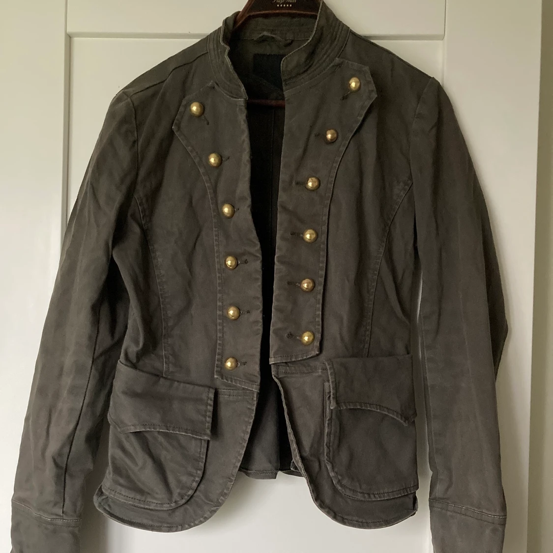 Militärgrön kavaj med guldiga detaljer