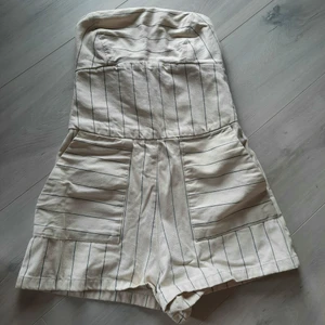 Zara Playsuit. Stl XS - Superfin playsuit som tyvärr blivit för liten. Från Zara. Stl XS. Randigt "jeans" material. Axelbandslös, dragkedja bak, fickor framtill. Superfint skick! Skicka meddelande för fler bilder eller frågor 🥰