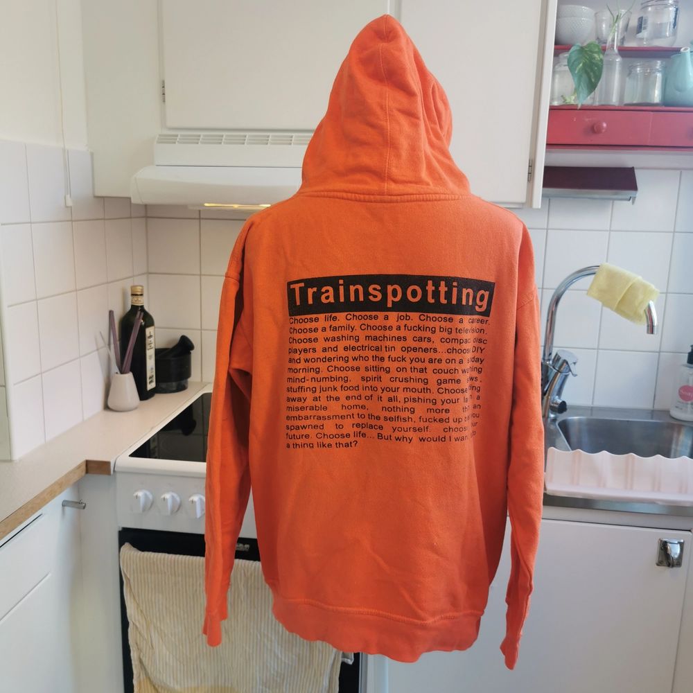Cool alternativ hoodie som jag köpt under av mina turer till London, använd ca 2-3ggr och sedan gömts i garderoben. Hoodien är lysande orange med svart tryck och citat från kultklassikern Trainspotting från -96, ett läckert plagg i en alternativ garderob 🖤. Huvtröjor & Träningströjor.