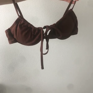 Brun bikini - En jättefin brun bikini, endast testad en gång och har alla skyddslappar kvar! I storlek medium men kuporna är mer som en small. Reglerbara band :)