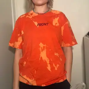 Orange oversized t-shirt med tryck på bröstet och på ryggen. Hand blekt den. Skulle säga att storleken är med XL