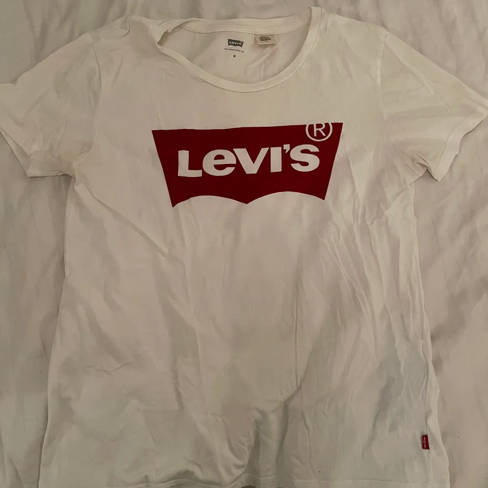En vit T-shirt med det vanliga röda trycket ifrån Levis. Använt ett fåtal gånger. Köpare står för frakten (66kr och går att spåra eller att vi tillsammans bestämmer ett billigare pris för frakt)💕. T-shirts.