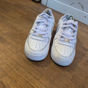 Vita Nike Air Force 1 - Helt vita Nike air force 1 i storlek 38! Använda i några månader men tvättade så att de ser helt nya ut. Ser helt nya ut förutom de små skador som är på bild 2,3. Skadan på bild 2 syns knappt. ( märkte den inte själv förens jag kollade nära och noga) om många är intresserade blir det budgivning!