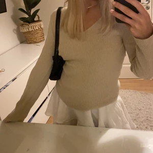 Beige tröja - En snygg beige långärmad tröja med v-ringad hals. Superbekväm. Den är liten i storleken men extremt stretchig i tyget.
