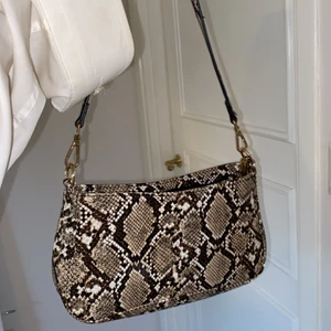 Axelväska - En snygg axelväska i perfekt storlek med ett orm mönster. Superbra skick!