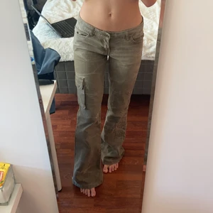 Lågmidjade byxor - Galet snygga beige/grå lågmidjade byxor med coola detaljer😇😇 pyttelite långa på mig som är 166 cm😊 de är lite slitna längs ner, skriv privat för bild! <3 midjemåttet: 38cm rakt över, innerbenslängd: 83cm