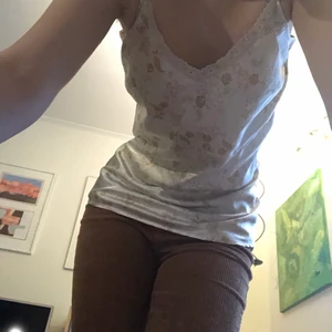 Vitt silkes linne - Ett vitt linne i silkesliknande material med brun-beigt mönster på, fint skick! Skriv för frågor eller fler bilder