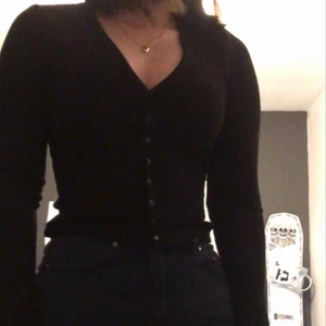 Ribbad top strl XS - Ordinariepris 149kr. Ribbad svart topp med v-ring och har knappar som öppning, den är lite varm för sommaren  men passar perfekt till svalare dagar. Klädesplagget är  i mycket fint skick som används 4 ggr. Säljer pga den är lite tajt för mig.
