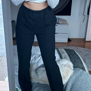 Byxor  - Raka kostymbyxor i tyg/fleece material med mörkgrå färg. Resorband i midjan som gör de väldigt sköna, en ficka. Går att använda likaväl som snygga mjukisar som snygga byxor till vardagen. Säljes för 150kr+frakt.