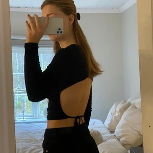 Svart topp med öppen rygg - En långärmad topp med öppen rygg, aldrig använd! 