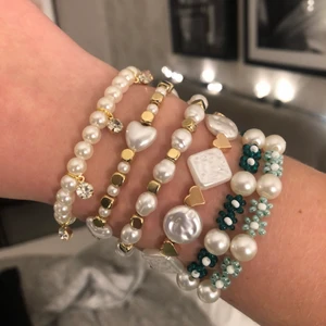 Pärlarmband - Pärlarmband som jag gjort själv🖤🖤 Kolla in mina andra annonser för massor av andra egengjorda smycken!! Ni får även komma med egna förslag på färg och design🥰 Pris för de fyra armbanden närmast min hand, alltså alla dem med vita och guldpärlor: 35kr/styck, pris för de andra två med blommor och stora vita pärlor: 40kr/styck. Frakt tillkommer på 13kr!!