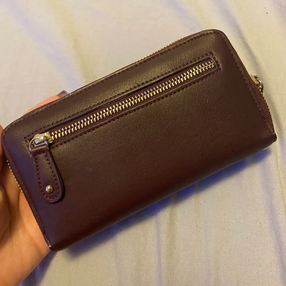 En plånbok med telefon hållare, aldrig använd i fint skick. Kommer även med ett snöre att kunna hålla den med.. Övrigt.