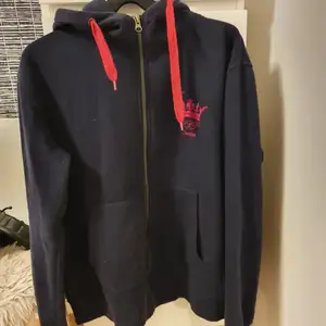 Marinblå zip hoodie med rosa detaljer. Använd men i bra skick storlek L 