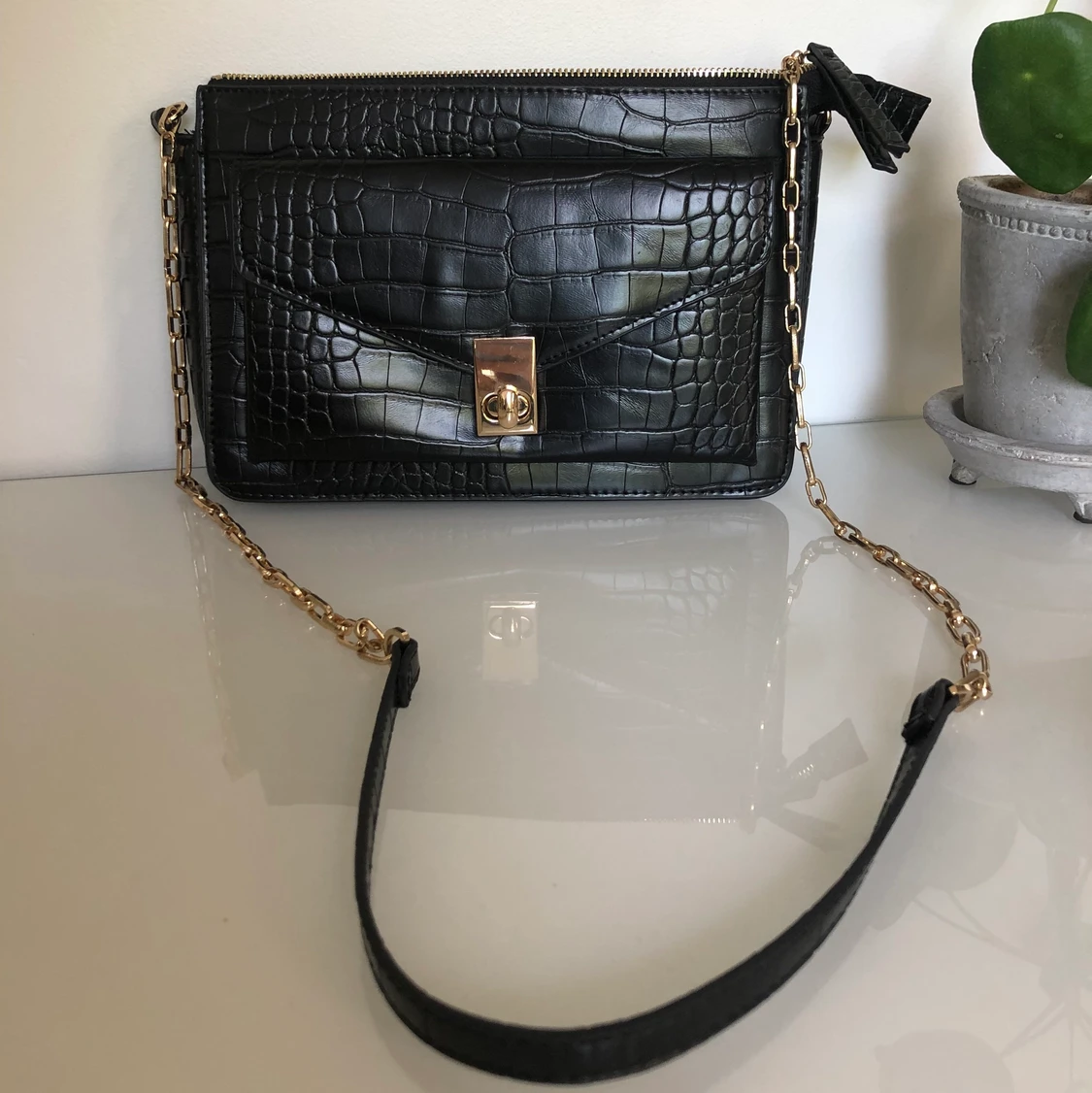 Svart axelväska med guldiga detaljer 