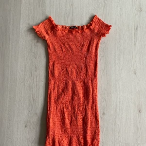 Klänning - Bilden gör inte färgen rättvisa! Är lite orange/korall färgad. Formar sig snyggt efter kroppen