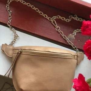 beige väska  - beige väska med gulddetaljer, går att justera guldkedjan efter önskan. aldrig använd! Leverans: kunden står för kostnaden 