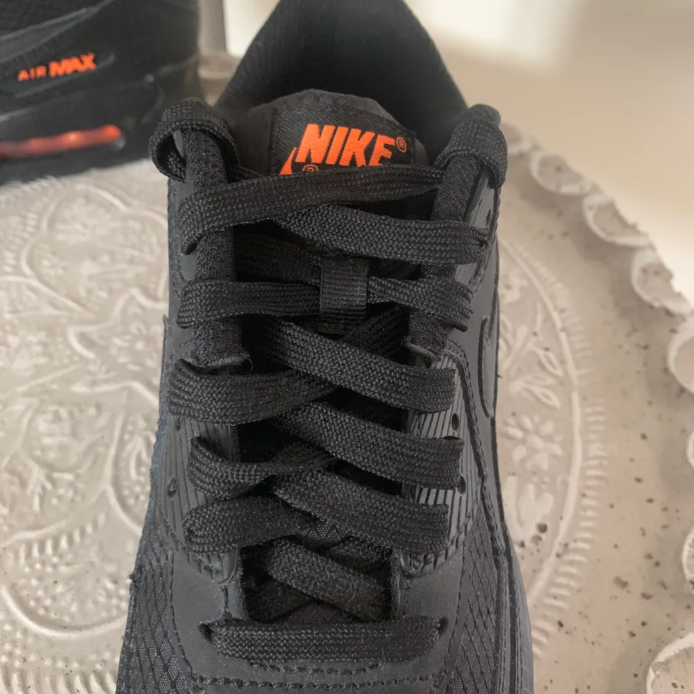 Ett par nya svarta Nike Air Max med orangea detaljer. Dessa är endast använda en gång men sedan insett att dem var för små, skriv för frågor 🙌🏼. Skor.