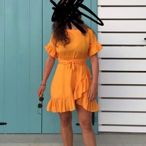 Orange fin klänning med volanger och knyte i midjan i linneaktigt tyg. Storlek 34. Från nelly