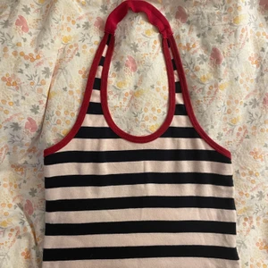 Halterneck linne i rosa, blått och rött - Randig halternecktopp i ljusrosa och mörkblått. Det är omsytt i nacken då det är barnstorlek från början men det märks inte så mycket. Passar storlek s. Möts i Stockholm annars betalar köpare frakt. 