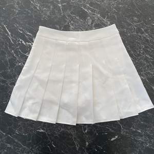 Vit ”pleated/schoolgirl skirt” med inbyggda shorts under! Använd 1 gång, så den är i jättebra skick. Dragkedja på sidan. Är i storlek S. Midjemåttet är cirka 70 cm.💥💥Högsta bud 250kr💥💥 KÖP DIREKT FÖR 300kr!!