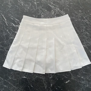 Kjol - Vit ”pleated/schoolgirl skirt” med inbyggda shorts under! Använd 1 gång, så den är i jättebra skick. Dragkedja på sidan. Är i storlek S. Midjemåttet är cirka 70 cm.💥💥Högsta bud 250kr💥💥 KÖP DIREKT FÖR 300kr!!