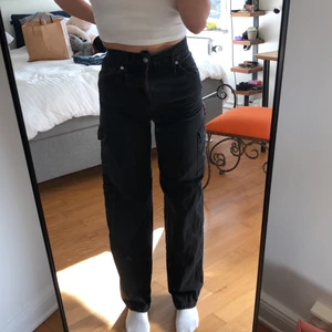Pull&Bear Cargo Jeans - Vanliga svarta cargo jeans från pull and bear. Använd men är i bea kvalite, har även gått och lagat drag kjedjan! Super sköna pch snygga.