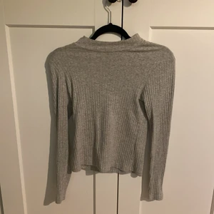 En grå tröja med krage  - En grå tröja med krage använd ca 3 gånger, väldigt bra skik sitter inte för tajt.