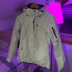 Skidjacka Peak Performace strl xs - Vit skidjacka från peak performance. Mycket gott skick. Varm och perfekt till skidsäsong. Luvan är avtagbar.