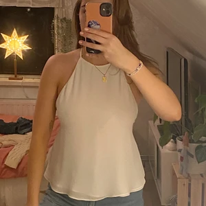 Vit festtopp - zara - Säljer min fina topp från zara som är köpt för något år sedan. Använt 2 ggr så i nyskick skulle jag säga. Den är i strl S och jag är en M så lite litet för mig, därför säljer jag. Har en knapp i nacken så man få av och på sig den och sen en super snygg knytning i ryggen😍 Skriv om ni har frågor eller vill ha mer bilder, frakt tillkommer!🐻