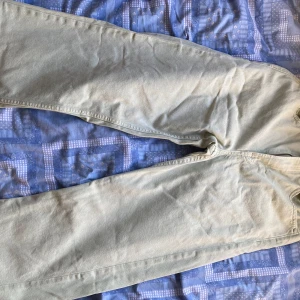 Mint gröna raka jeans - Säljer ett par ljusbeige jeans med rak passform. Byxorna har klassisk femficksdesign och är tillverkade i ett mjukt bomullsmaterial. Perfekta för en avslappnad och stilren look.