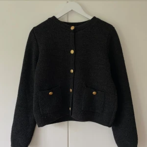 Svart kofta med guldknappar - Säljer min mörkgrå stickade kofta med guldknappar framtill då den inte kommer till användning! Den är i fint skick och har inga synliga defekter! Hör gärna av dig om du har några frågor!🤍