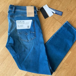 Replay Hyperflex Anbass jeans blå - Snygga blå Replay Hyperflex Anbass jeans i slim fit. Jeansen är tillverkade i stretchigt denim med klassisk femficksdesign och har en ljusblå tvätt. Perfekta för dig som vill ha bekväma och stilrena jeans med modern passform.