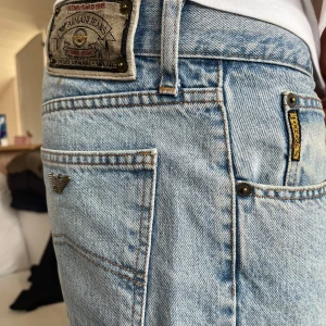 Ljusblå Armani Jeans straight fit - Klassiska ljusblå jeans från Armani Jeans med raka ben och normal passform. Dom har snygga detaljer som metallogo på bakfickan och tydlig patch i midjan. Tillverkade i robust denim. Uppskattningsvis w29, l30 