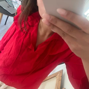 Röd blus - Gullig röd blus med volangdetaljer. Den är som ny och från Kappahl! Står inte storlek men skulle gissa S-L ungefär😊