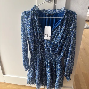 Blå klänning från Zara  - Supersnygg klänning med smockad midja från Zara. Som passar perfekt nu till sommaren. Aldrig använd, med prislapp kvar. Nypris 400 