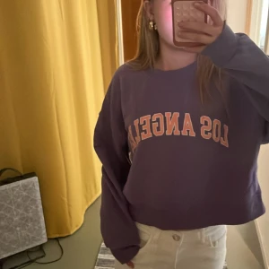 sweatshirt Pull&Bear - Lila sweatshirt från Pull&Bear med trycket 'Los Angeles' i vitt och orange på bröstet. Står storlek S men skulle säga xxs/xs Inga defekter och helt ren, kan dock tvättas innan jag postar om så önskas! 