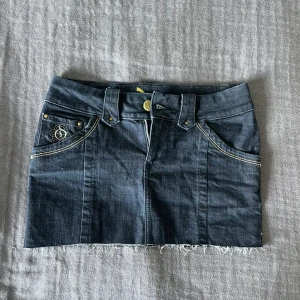 Mörkblå lågmidjad jeanskjol  - Snygg mörkblå och lågmidjad jeanskjol från Only. Den sitter jätteskönt och är i storlek S. Perfekt för sommaren! 